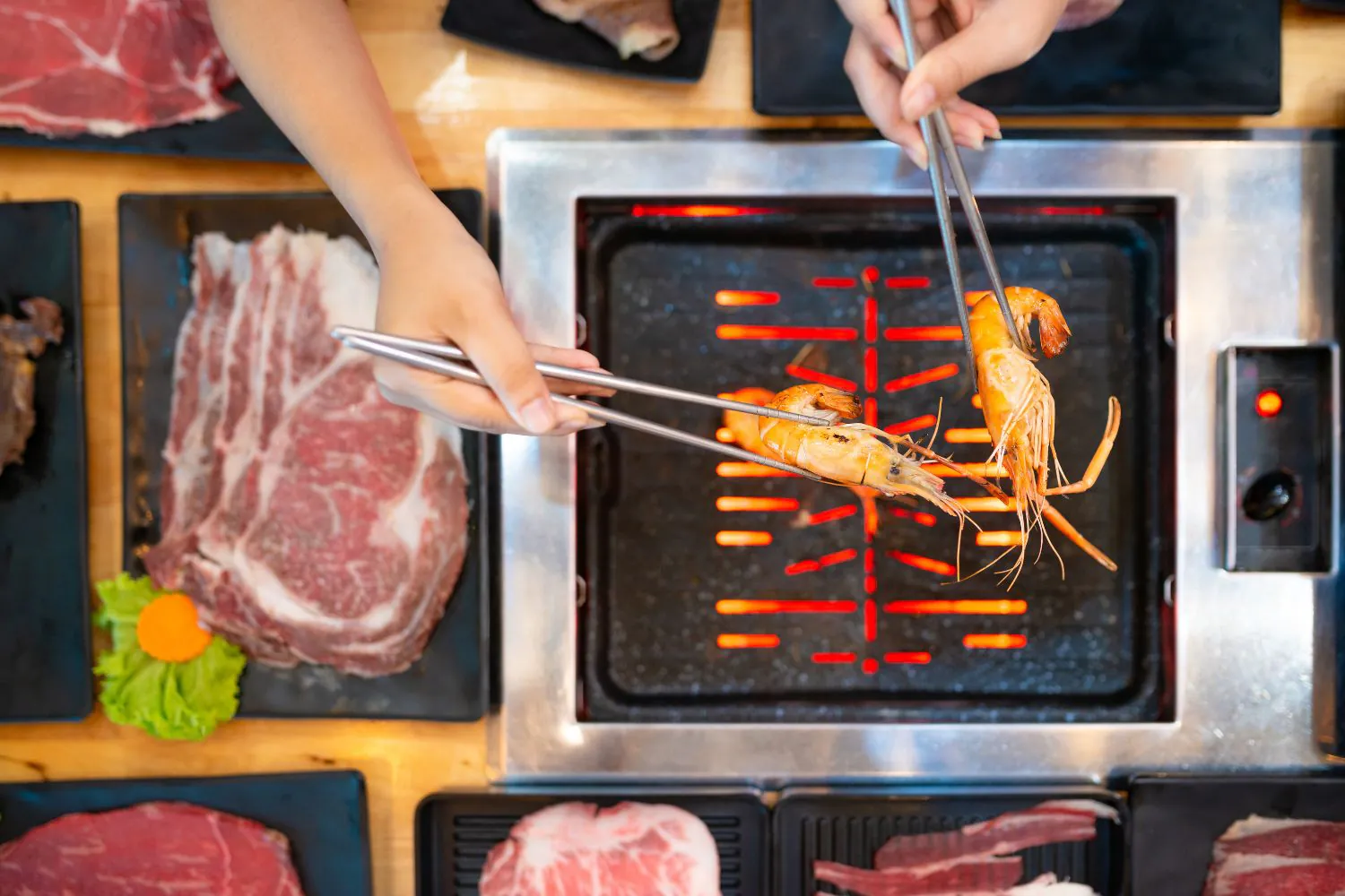 Shrimp being grilled at the table alongside assorted meats at Lucky 199, a Asian Fusion Restaurant in Staten Island